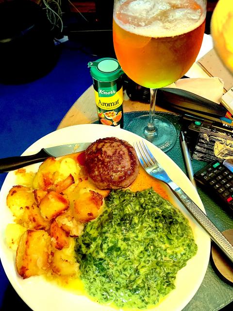 A Wagu burger with spinach and potatoes