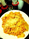 A Spaghetti, chicken, onion, tomato and cheese supper.