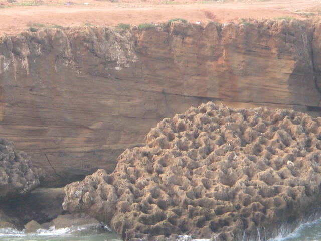 Holes pitted by salt water in solid stone